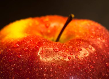 Su damlalarıyla kaplı kırmızı bir elmanın yakın çekimi