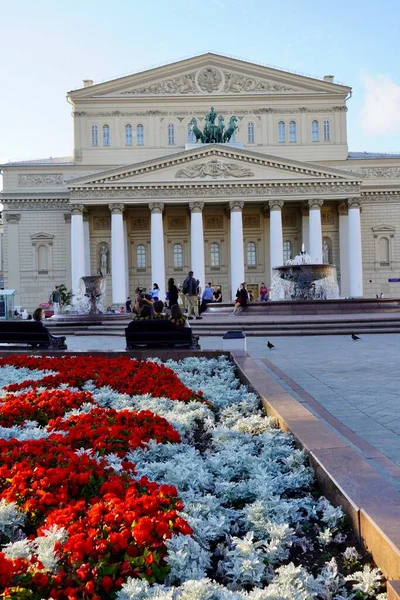 Moskva, Rusko - srpen 2020: Krásný letní výhled na divadlo Bolshoi s turisty v centru Moskvy, hlavní atrakce Ruska, Letní krajina s kvetoucími záhony — Stock fotografie