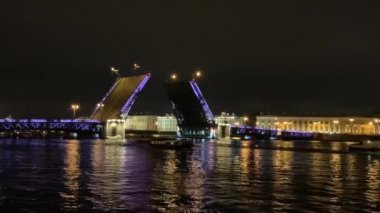 St. Petersburg 'da 4K ünlü asma köprü boşanması. Mavi ışıklı Saray Köprüsü yaprakları yavaşça çizilmiş, karanlık Neva Nehri, bir sürü turistik tekne etrafta dolanıyor, insanlar her gece izliyorlar. Çarpıcı bir manzara.