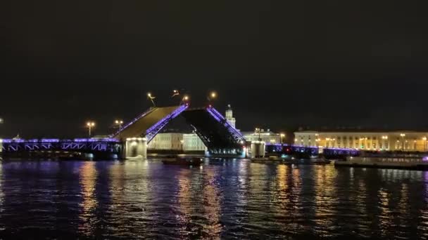 4K famoso divórcio ponte levadiça em São Petersburgo. Azul iluminado Folhas Palace Bridge elaboradas lentamente, escuro Rio Neva, muitos barcos turísticos bagunçar ao redor, as pessoas assistem show noturno. Paisagem deslumbrante — Vídeo de Stock