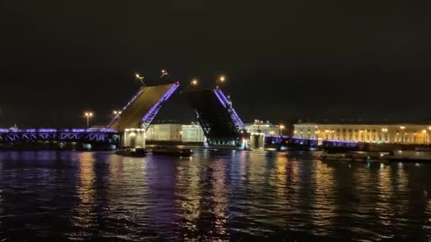 4K famoso divórcio ponte levadiça em São Petersburgo. Azul iluminado Folhas Palace Bridge elaboradas lentamente, escuro Rio Neva, muitos barcos turísticos bagunçar ao redor, as pessoas assistem show noturno. Paisagem deslumbrante — Vídeo de Stock