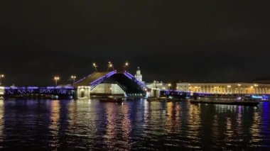 St. Petersburg 'da 4K ünlü asma köprü boşanması. Mavi ışıklı Saray Köprüsü yaprakları yavaşça çizilmiş, karanlık Neva Nehri, bir sürü turistik tekne etrafta dolanıyor, insanlar her gece izliyorlar. Çarpıcı bir manzara.