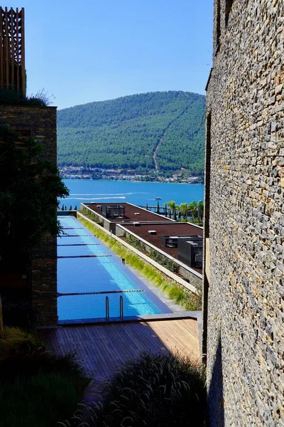 Schicke Aussicht auf den Strand und die smaragdgrüne Lagune, Swimmingpool zwischen den Mauern mit Mauerwerk. — Stockfoto