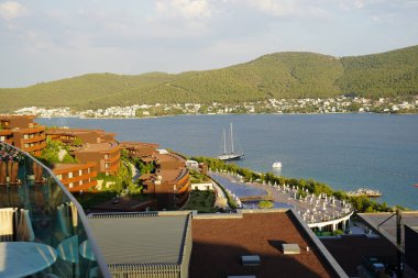  Panoramik manzara inanılmaz plaj ve Türkiye 'nin en iyi plajlarından biri olan Mavi Göl - Bodrum, Türkiye. Yeşil tepeler ve dağlar, adalar, Slim selvi ve beyaz yatların çarpıcı manzarası, lüks turizm 