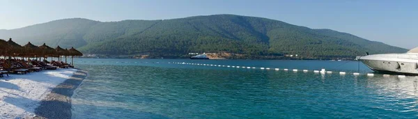 Bodrum, Turkey - August, 2020 Stunning panoramic view of island with palm trees, white sand, turquoise ocean water and blue sky, Water bungalow, white boats — Stock Photo, Image