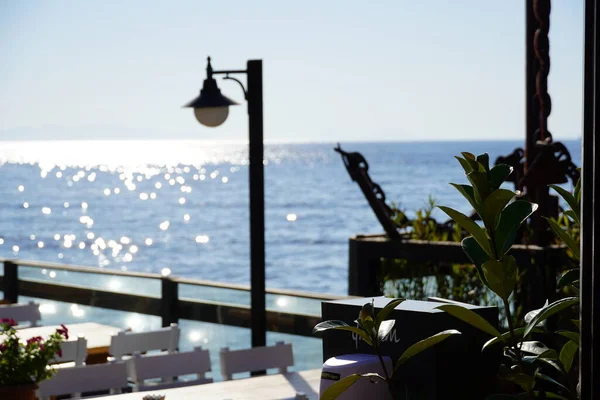 Café im Freien mit schickem Blick auf die Bucht, Holztisch und -stühle am Meer, offenes Café-Restaurant im Freien in Marina Bay, Bodrum - Türkei am Meer. Sommerurlaub am Urlaubsort. — Stockfoto