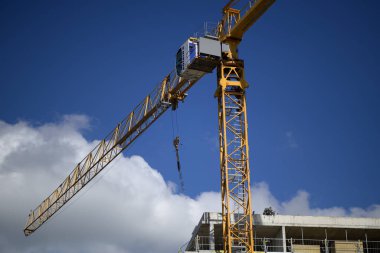 4 Haziran 2024 'te Sırbistan' ın Belgrad kentinde bulutlu mavi gökyüzüne karşı sarı bir inşaat vinci