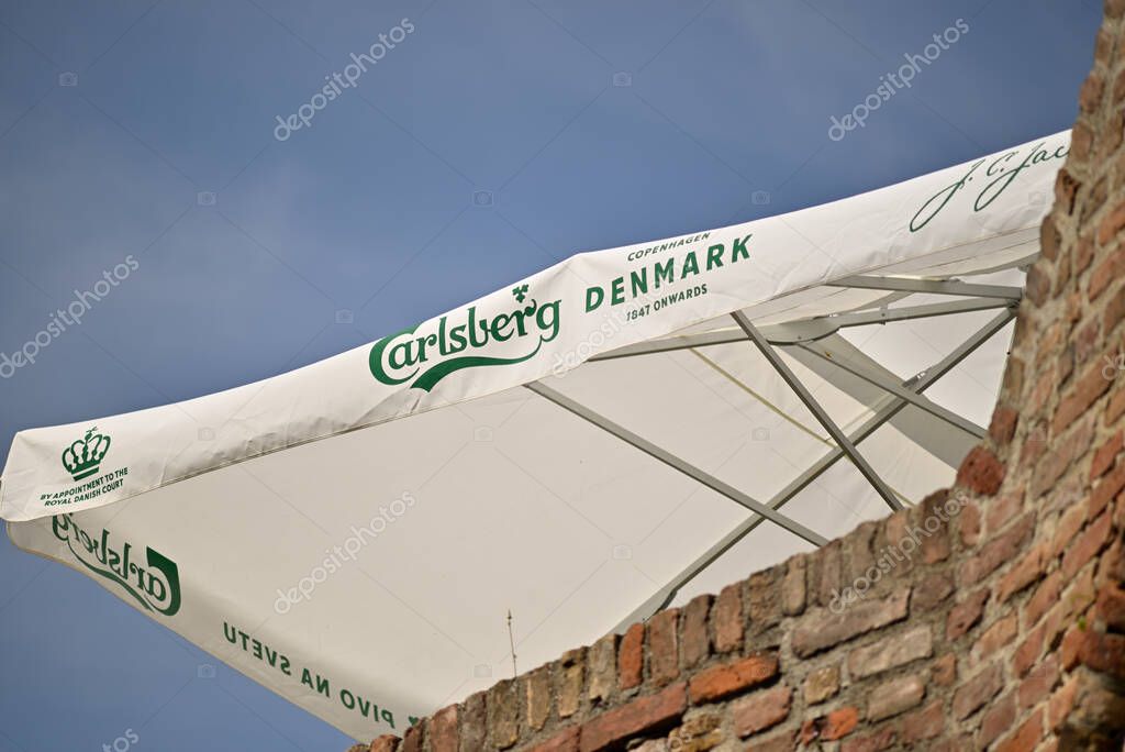 Outdoor patio umbrella with Carlsberg branding against blue sky, in Belgrade, Serbia on 8 June 2024