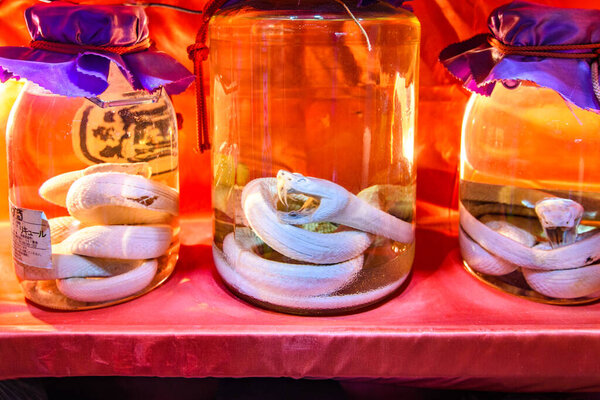 Кувшины из змеиного вина Окинавы, традиционного окинавского сакэ Habushu Habu Sake, приготовленного путем вливания ядовитой змеи в рисовый ликер Авамори в Нахе, Окинава, Япония, 26 февраля 2018 года