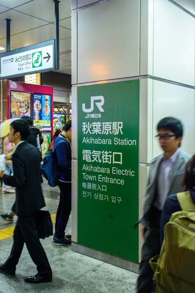 Люди, проходящие мимо знака на станции Акихабара в Токио, Япония 20 октября 2017 года