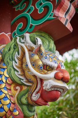 Close-up of a colorful, ornate dragon sculpture with intricate details.