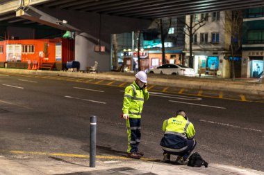 29 Ocak 2024 'te Güney Kore' nin Seul şehrinde gece yol taraması yapan güvenlik ekipmanlı iki işçi.