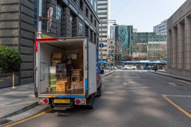 15 Mart 2024 'te Seul, Güney Kore' de şehir sokağına park edilmiş bir kargo kamyonu, arkası açık olarak kutuları gösteriyor.