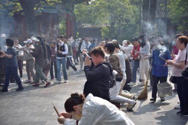 Çin 'in Pekin bölgesindeki Dongcheng bölgesinde 21 Nisan 2024' te Tibet Budizmi Yonghe Tapınağı 'nda insanlar tütsü yakıp dua ediyor.