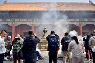 Çin 'in Pekin bölgesindeki Dongcheng bölgesinde 21 Nisan 2024' te Tibet Budizmi Yonghe Tapınağı 'nda insanlar tütsü yakıp dua ediyor.