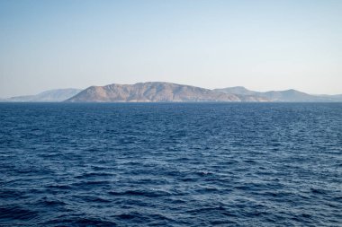 Berrak mavi gökyüzünün altında sakin bir deniz.