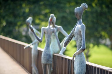 Köprü parmaklıklarında insan figürlerinin soyut heykelleri.