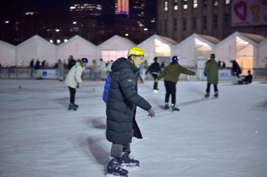 İnsanlar 29 Ocak 2024 'te Güney Kore' nin Seul kentindeki belediye binasının önündeki geçici buz pateni pistinde buz pateni yapıyorlar.