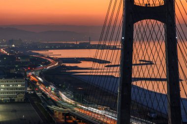 28 Kasım 2017 'de Japonya' nın Osaka kentinde, altında sakin sular bulunan, araçlardan hafif patikaları olan bir köprünün hava günbatımı görüntüsü