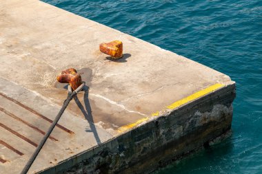 Deniz kıyısındaki beton bir iskelede paslanmışlar..