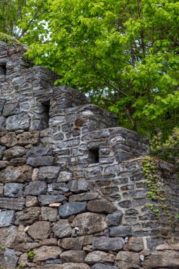 Arka planda yeşil merdiven olan taş duvar..