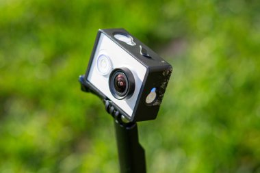 Dışarıdaki bir direğe yerleştirilmiş kompakt kamera, sığ alan derinliği ve yeşil bulanık arkaplan ile yakın plan..