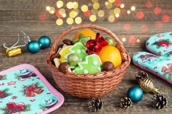 Colorful Christmas basket with treats on a wooden background. Selective focus