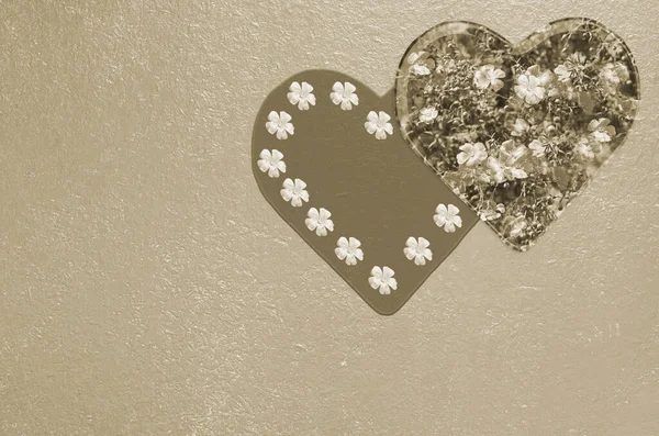 Wooden background with hearts and flowers tinted with sepia