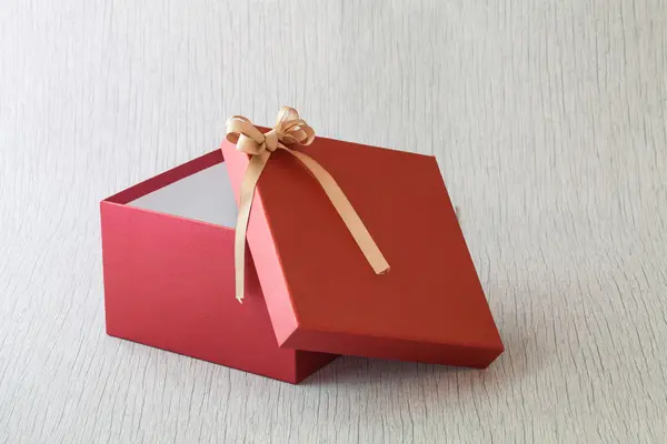 Red gift box for someone special on wood background — Stock Photo, Image