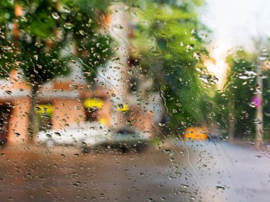 Mavi cam arka plan üzerinde yağmur damlaları. Sokak Bokeh ışıklar 