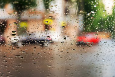 Mavi cam arka plan üzerinde yağmur damlaları. Sokak Bokeh ışıklar 
