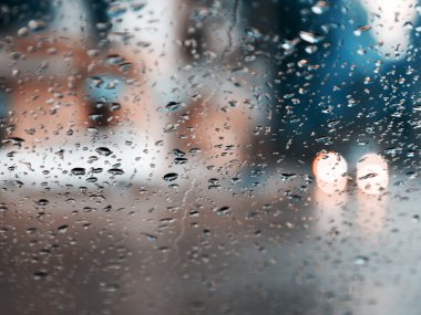 Mavi cam arka plan üzerinde yağmur damlaları. Sokak Bokeh ışıklar 