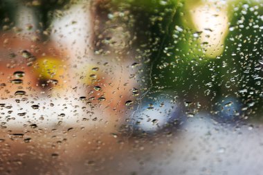 Mavi cam arka plan üzerinde yağmur damlaları. Sokak Bokeh ışıklar 