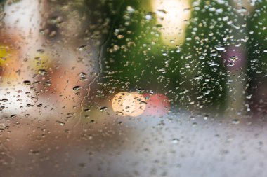 Mavi cam arka plan üzerinde yağmur damlaları. Sokak Bokeh ışıklar 