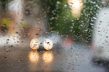 Mavi cam arka plan üzerinde yağmur damlaları. Sokak Bokeh ışıklar 