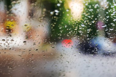 Mavi cam arka plan üzerinde yağmur damlaları. Sokak Bokeh ışıklar 