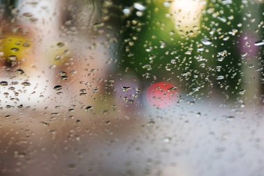 Mavi cam arka plan üzerinde yağmur damlaları. Sokak Bokeh ışıklar 