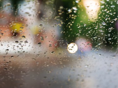 Mavi cam arka plan üzerinde yağmur damlaları. Sokak Bokeh ışıklar 