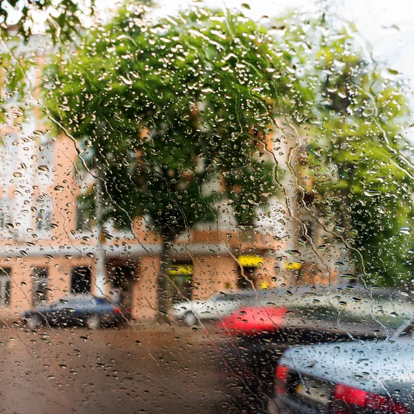 Gotas de chuva em fundo de vidro azul. Rua Bokeh luzes apagadas — Fotografia de Stock