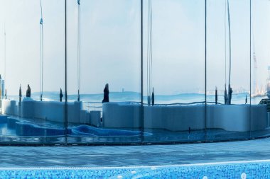 Evin aynalı pencerelerinde deniz ve şehir duvarlarının yansıması..