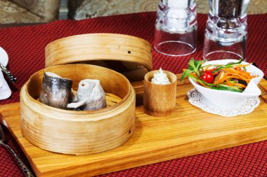 Sofra takımı, buğulama balık, salata, çatal bıçak takımı ile ahşap Kupası. Yaratıcı 