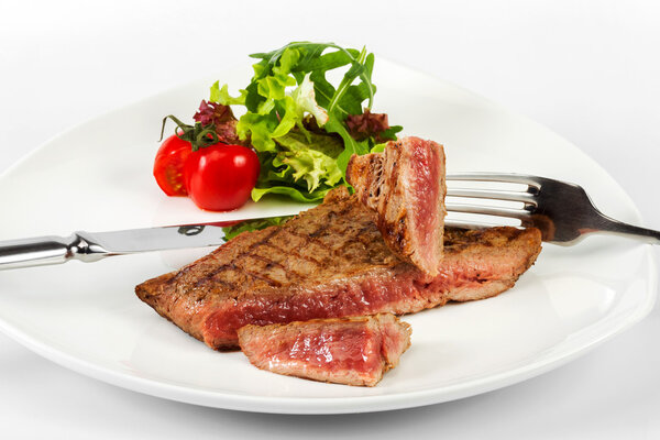 Steak with blood of beef with tomatoes, herbs and lettuce, servi