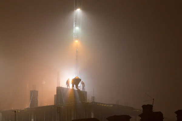 Construcción por la noche en la niebla —  Fotos de Stock