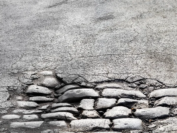 Cutting of an old road with cracked asphalt and a gully in the c — Stock Photo, Image