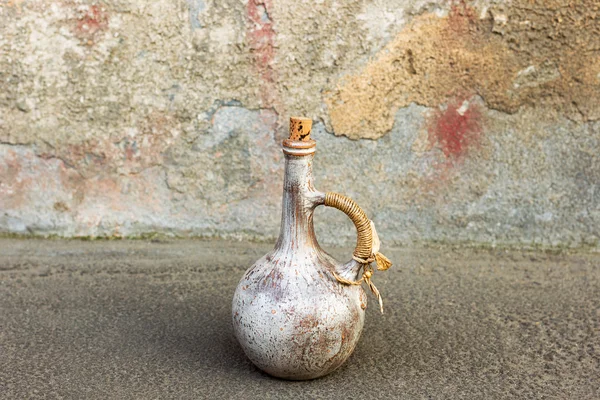 Old ceramic jug on a road near the oldness of the rough wall — Stock Photo, Image