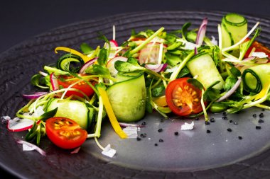Siyah bir plaka üzerinde lahanası ve bezelye karabiber ile otantik taze sebze salatası. Sabah atmosferik aydınlatma, moda trendy spot yumuşak odak. Tasarım yaratıcı menüsü için hazırlık.