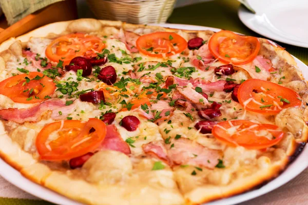 Hiteles pizza paradicsommal, füstölt kolbász, szalonna és petrezselyem — Stock Fotó