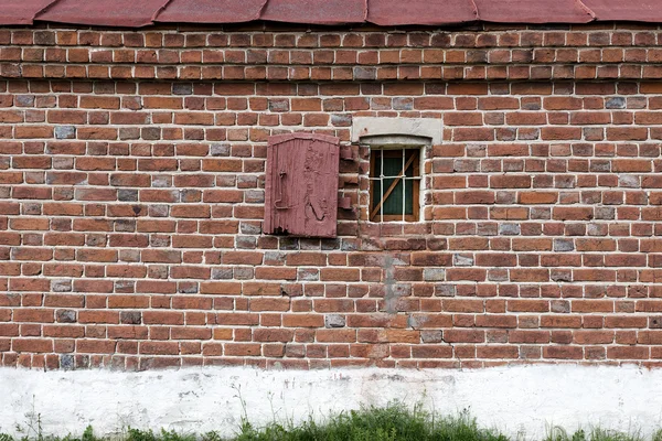 Vieja ventana con barras de metal creativas en la pared de piedra blanca — Foto de Stock