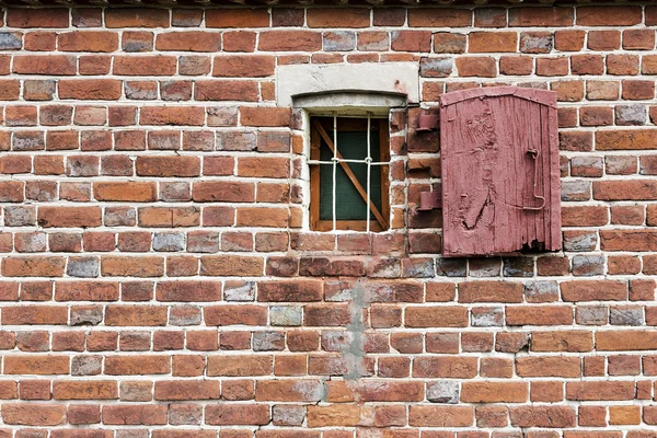 Staré okno kreativní kovovými mřížemi na bílé kamenné zdi — Stock fotografie