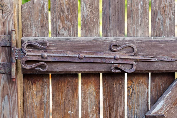 Vintage metal wrought iron hinges on the wooden door — Stock Photo, Image